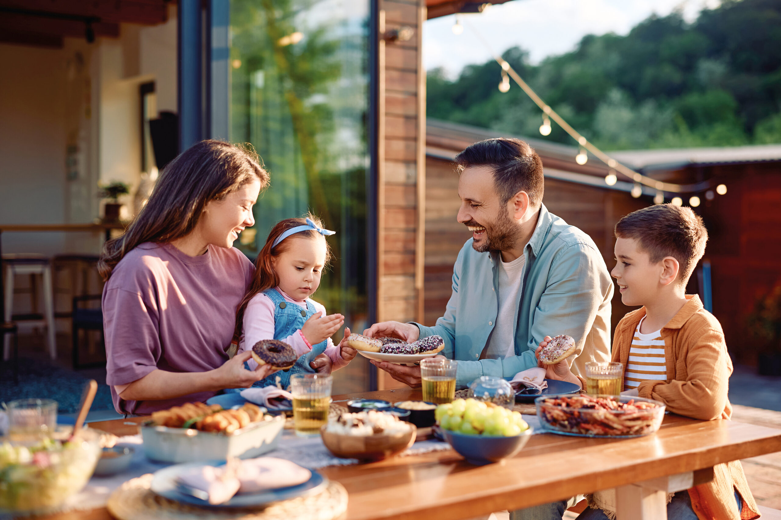 Happy family enjoying in dessert after having a lunch on their terrace.